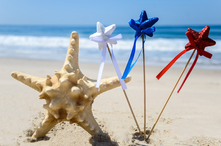 Patriotic USA background with starfish decorations on the sandy beachの写真素材