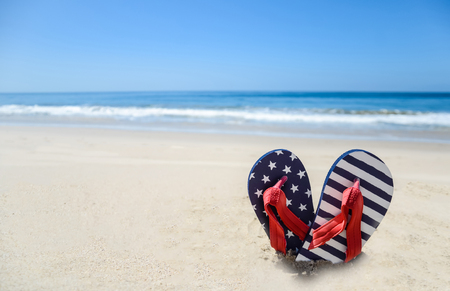 Patriotic USA background with flip flops on the sandy beachの写真素材