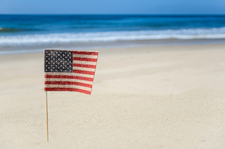 Patriotic USA background with flags and decorations on the sandy beachの写真素材