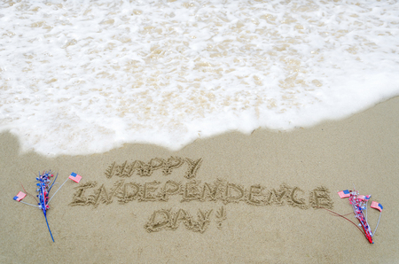 Independence Day USA background with american flag on the sandy beachの写真素材