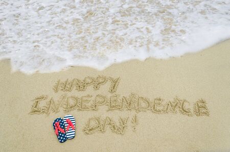 Independence USA  background with flip flops of american flag colors on the sandy beach near oceanの写真素材