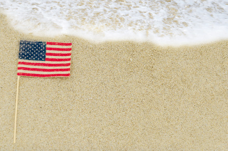 Patriotic USA background with american flag on the sandy beach