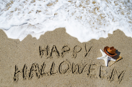 Halloween background with starfish and broom on the sandy beach near the oceanの写真素材