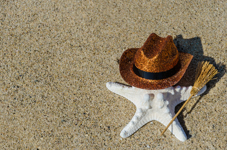 Halloween background with starfish with broom on the sandy beach near the oceanの写真素材