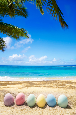 Happy easter background with eggs on the sandy beach near ocean.の写真素材
