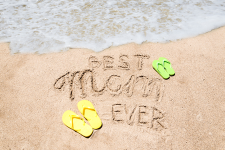 Happy Mother's day background on the sandy beach near the ocean. Sign Best Mom ever. Hand drawn lettering typographyの写真素材