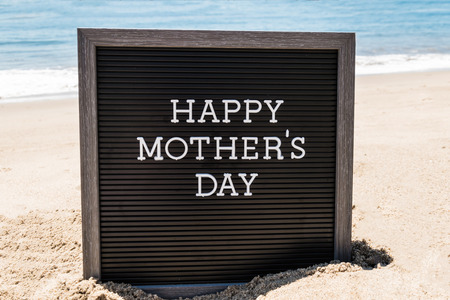 Happy Mother's day  with black board on the sandy beach near the ocean.の写真素材