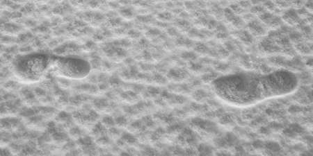 A couple of human footsteps over frozen snowの写真素材