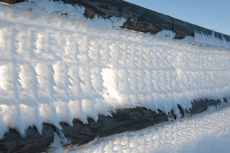 A close up of a fence with snow frozenの写真素材