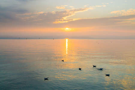Sunset from "Garda lake" Italian landscape. Sun reflected on lake. Water and skyの写真素材