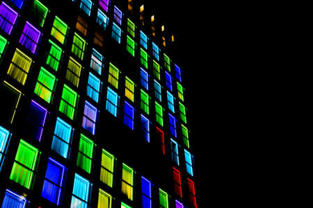 Colored windows texture.  Windows illuminated by neon lights background.の写真素材
