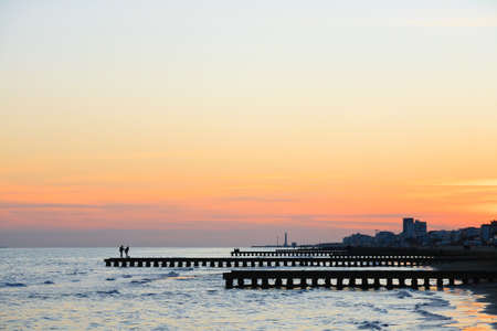 Beach landscape at dawn. Piers perspective view with people. Jesolo beach view, Italian panorama