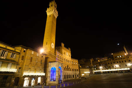 Night view of Campo Square (Piazza del Campo), Siena Palazzo Pubblico and Mangia Tower (Torre del Mangia) in Siena, Tuscany, Italy.の写真素材