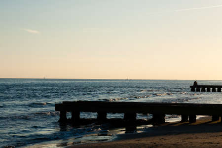 Beach landscape at dawn. Piers perspective view with people. Jesolo beach view, Italian panorama