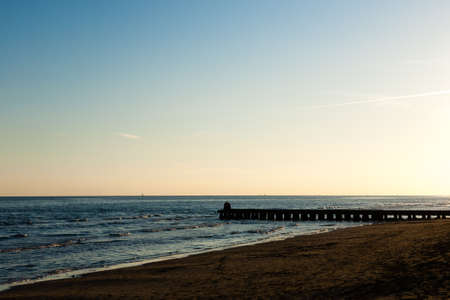 Beach landscape at dawn. Piers perspective view with people. Jesolo beach view, Italian panoramaの写真素材