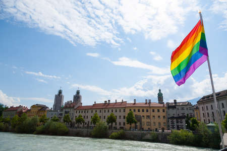 Innsbruck city center view. Rainbow flag over Inn River
