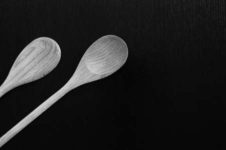 Wooden spoons on black table. Kitchen tools close upの写真素材