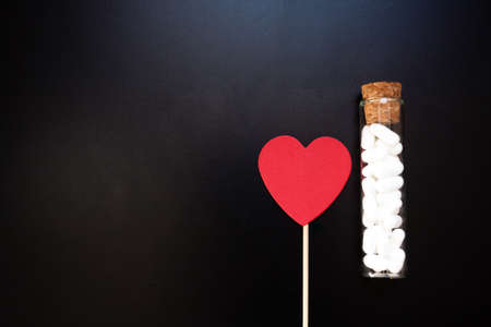 Jordan almonds and heart shape. Wedding decoration on black background. Confetti food