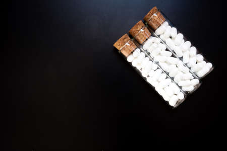 Jordan almonds in glass tube. Wedding decoration on black backgroundの写真素材
