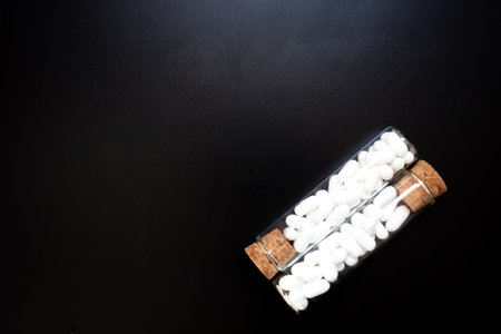Jordan almonds in glass tube. Wedding decoration on black backgroundの写真素材