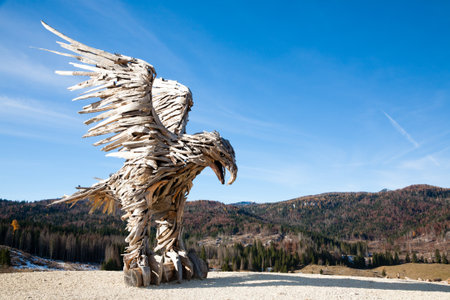 Wooden sculpture of an eagle made of tree branches. Vaia storm eagle