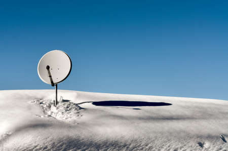 Sattelite dish Placed on the roof of mountain house covered of snowの写真素材