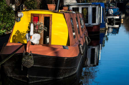 Boat, trees, birds are reflecting over Regent's Canal while people walks quietly along the river side.の写真素材