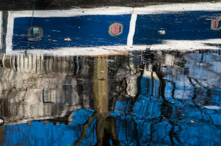 Boat, trees, birds are reflecting over Regent's Canal while people walks quietly along the river side.の写真素材