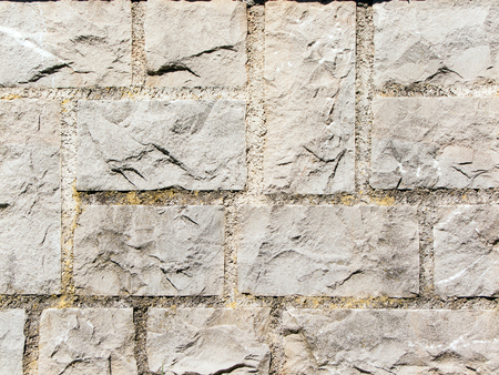 light gray square stone wall with cracksの写真素材