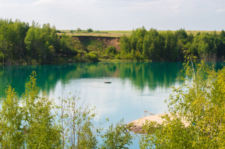 Man swims along the lake peaceful view of summer vacation