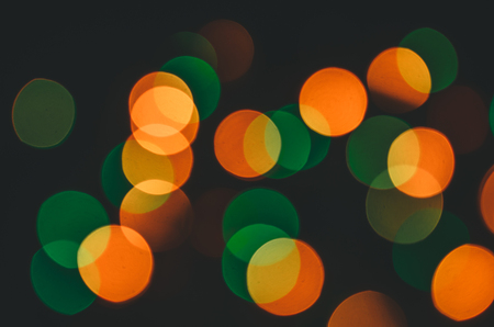 Red, yellow, green bokeh glow on black backgroundの写真素材