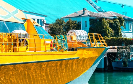 Yellow boat on the sea near houses in southern townの写真素材