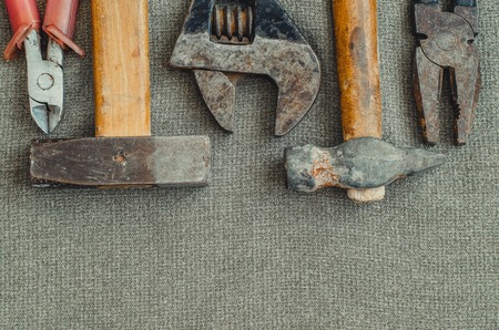 Top view layout of different tools as hammer, screwdriver, spanner and pliers on textile background with copy spaceの写真素材