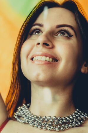 Young smiling woman in beads celebrates mardi gras close-up portraitの写真素材