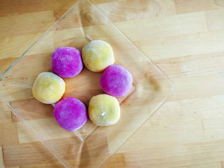 Colourful Japanese Mochi in a transparent plate on wooden background.の写真素材