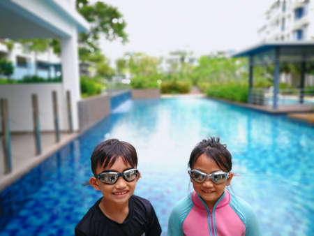 Portrait of asian kids, a boy and a girl wearing goggles.の写真素材