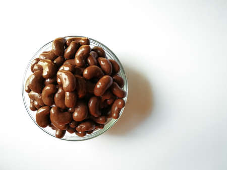Chocolate ball candy in a bean shape is isolated over the white background.