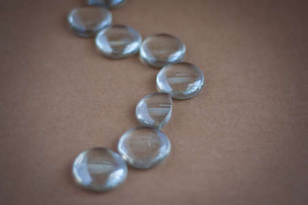 Clear marbles with light reflections on a brown background.の写真素材