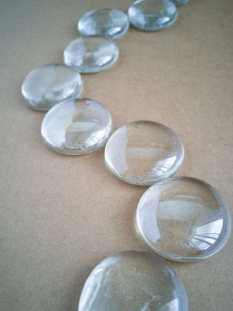 Clear marbles with light reflections on a brown background.
