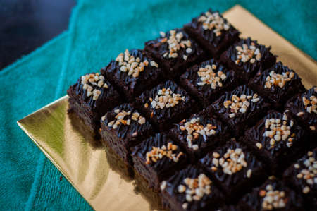 Chocolate Cake Brownie Squares Drizzled With Chocolate and Walnuts. Closeup view, selective focusの写真素材