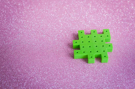 Colorful plastic puzzle pieces on pink Background.