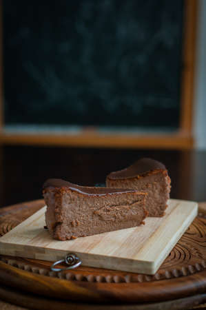 Burnt chocolate cheesecake on brown wooden background. selective focusの写真素材