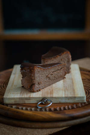 Burnt chocolate cheesecake on brown wooden background. selective focusの写真素材