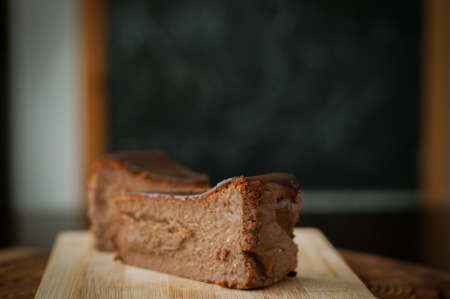 Burnt chocolate cheesecake on brown wooden background. selective focusの写真素材