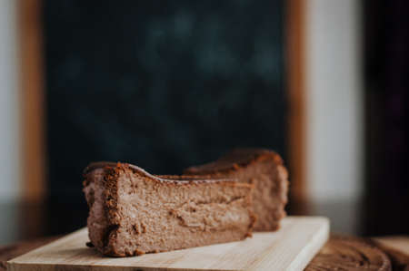 Burnt chocolate cheesecake on brown wooden background. selective focusの写真素材