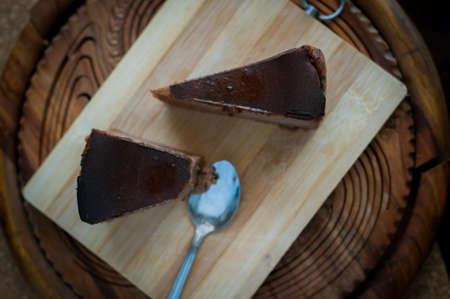 Burnt chocolate cheesecake on brown wooden background. selective focusの写真素材