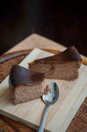 Burnt chocolate cheesecake on brown wooden background. selective focusの写真素材
