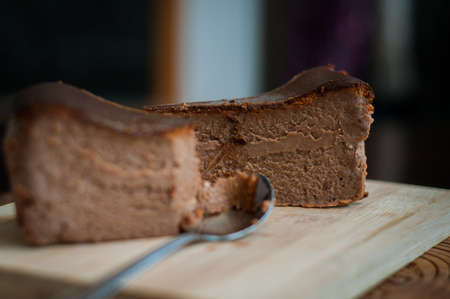 Burnt chocolate cheesecake on brown wooden background. selective focus