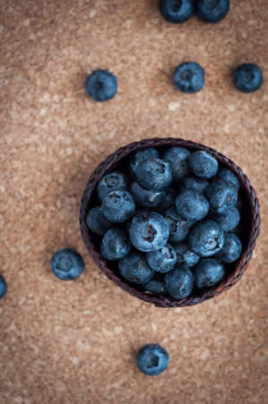 Freshly picked blueberries in woven natural screw pine leaf bowl. Juicy and fresh blueberries with on rustic table. Bilberry on wooden Background. Blueberry antioxidant. Concept for healthy eating.の写真素材