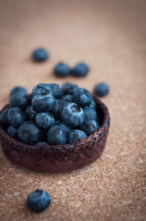 Freshly picked blueberries in woven natural screw pine leaf bowl. Juicy and fresh blueberries with on rustic table. Bilberry on wooden Background. Blueberry antioxidant. Concept for healthy eating.の写真素材